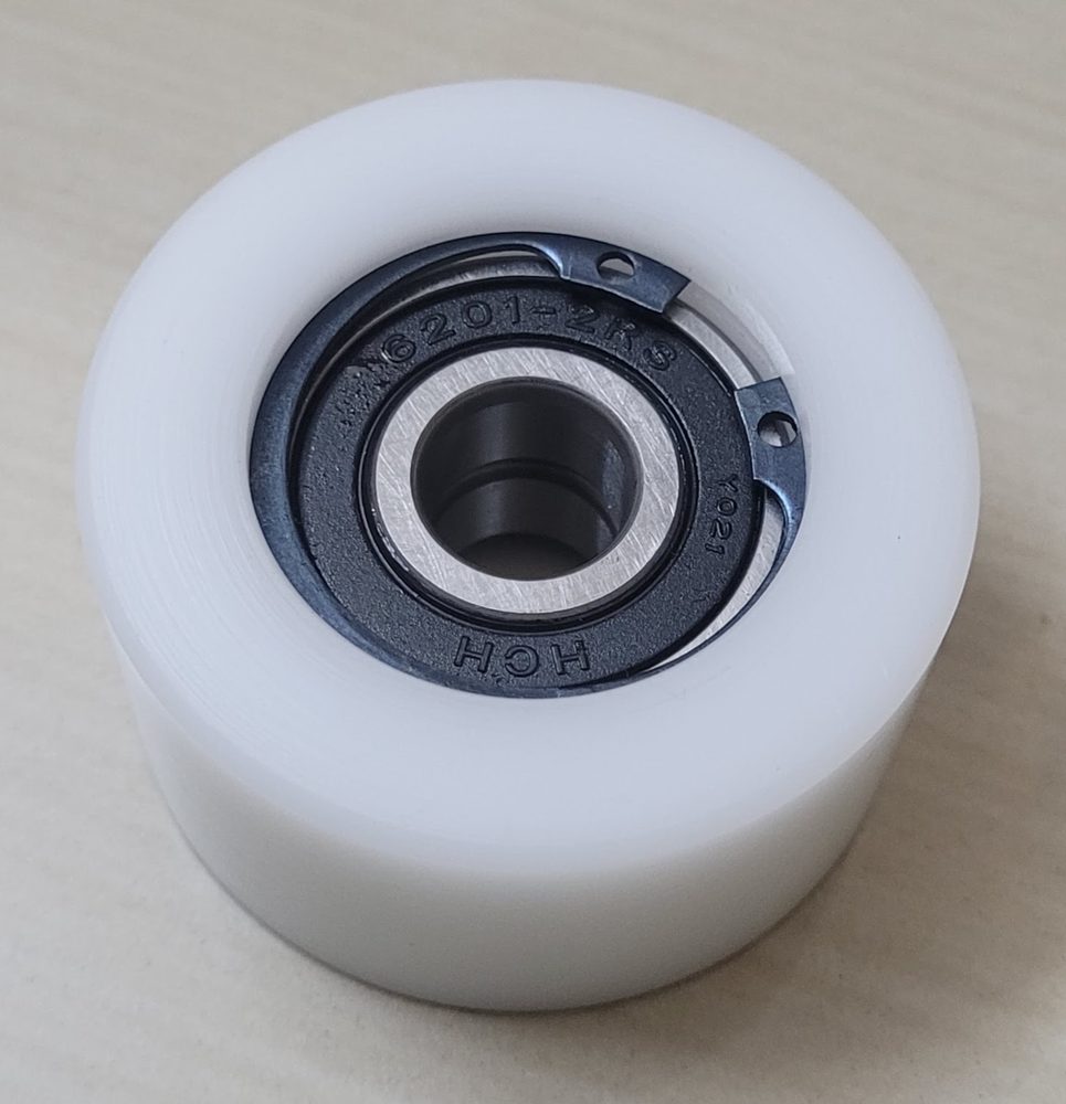 White nylon roller with a sealed bearing pressed into the bore