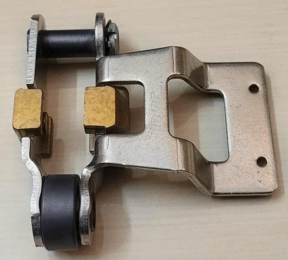 Textile machine linkage bracket with brass pads and rollers