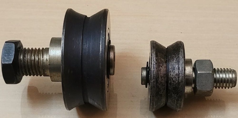 Two V-groove steel track rollers with threaded studs